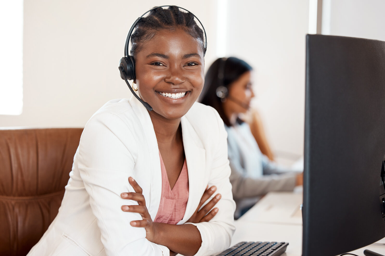 A friendly support counsellor smiling at her desk, ready to assist callers.